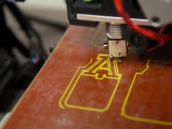 Device engraves University of Arizona logo into wood.