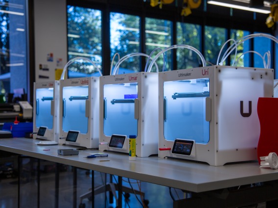 an image of a row of 3d printers on a long table