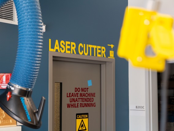 A sign on the wall that reads "Laser cutter."