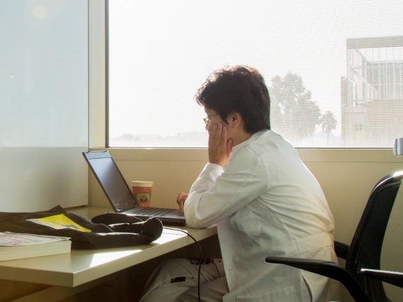 Women in white coat using a computer in a room