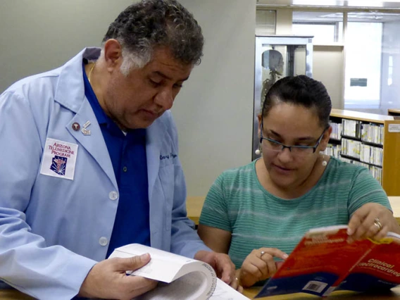 Two Health Sciences Library employees looking for information 