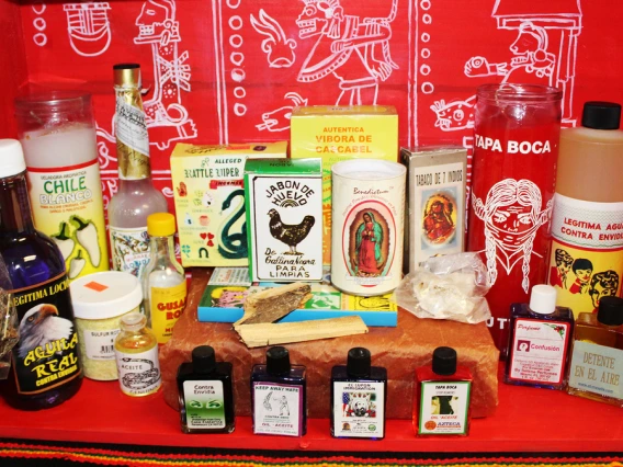 Bottles and candles displayed on a red cloth