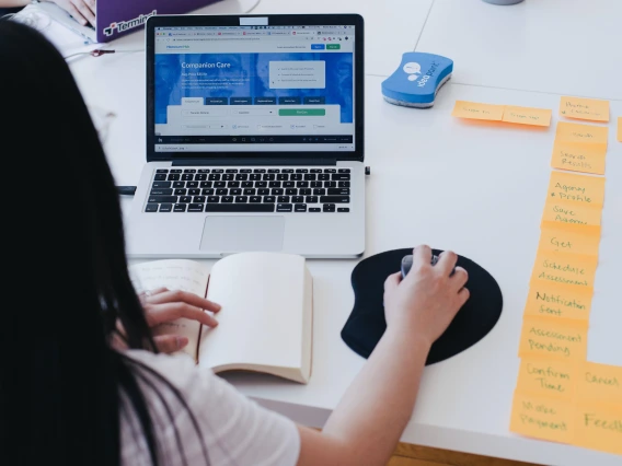 Woman using laptop with an external mouse