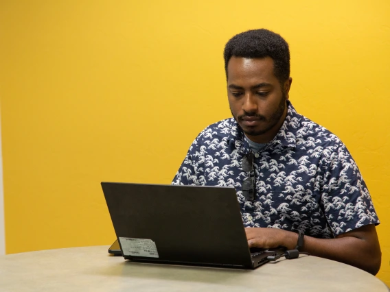 student with laptop studying in study room