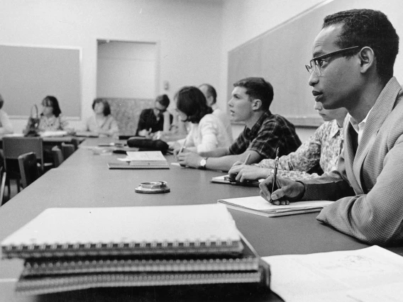 Unidentified UA students take notes in class during a lecture.