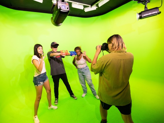 Students filming a video in the Green Screen Room