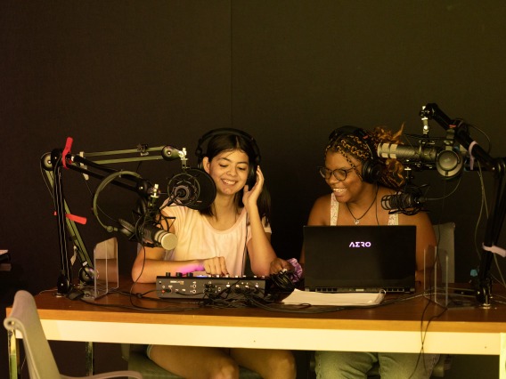 Two students recording a podcast together with microphones and other recording equipment in use