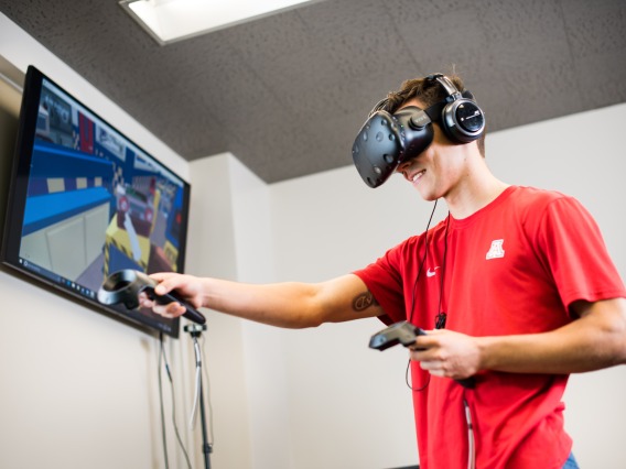 Student in a virtual reality (VR) experience, wearing a VR device and interacting with the virtual environment