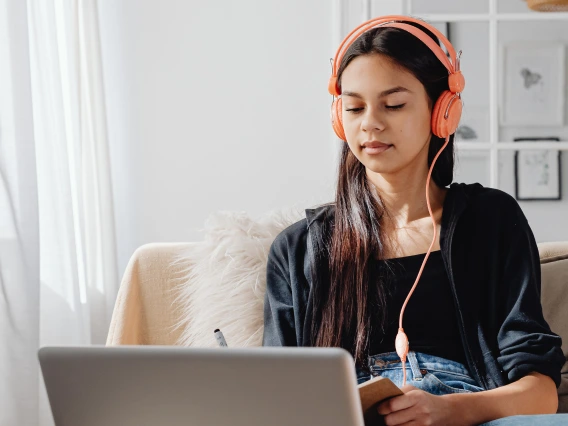 Student wearing headphones and looking at her laptop