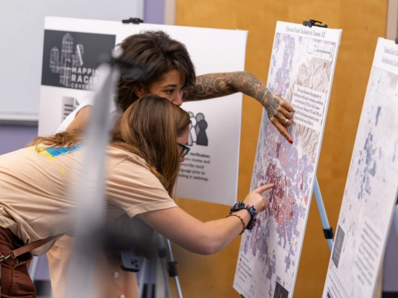 two people looking closely and pointing at a map