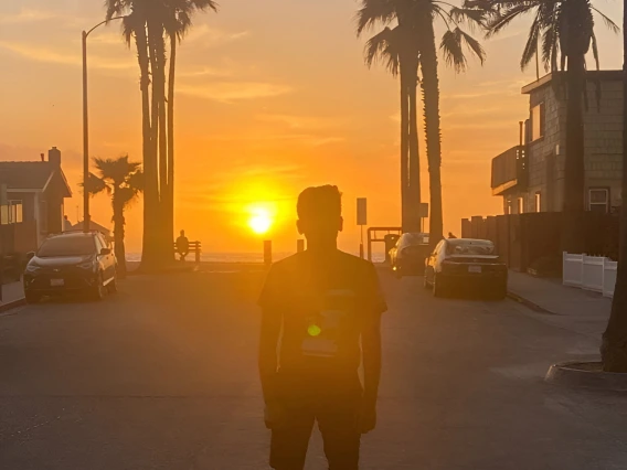 a shadow of a person standing in front of a sunset 
