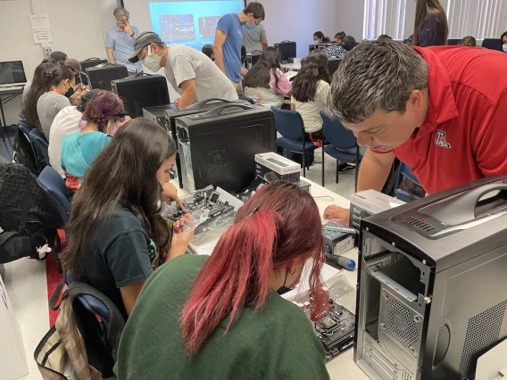 Library staff assisting students with technology.