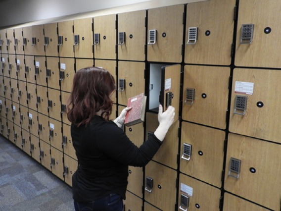 woman placing a book in a locker