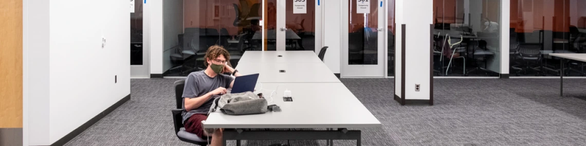 Student with a laptop studying in the library