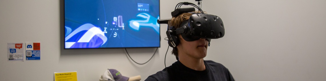 A student using the VR headset in front of a TV screen