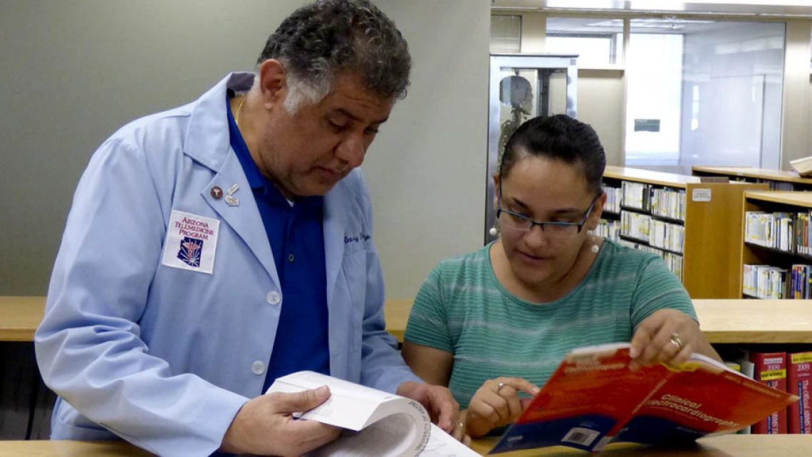 Health Sciences Library employees looking at books together