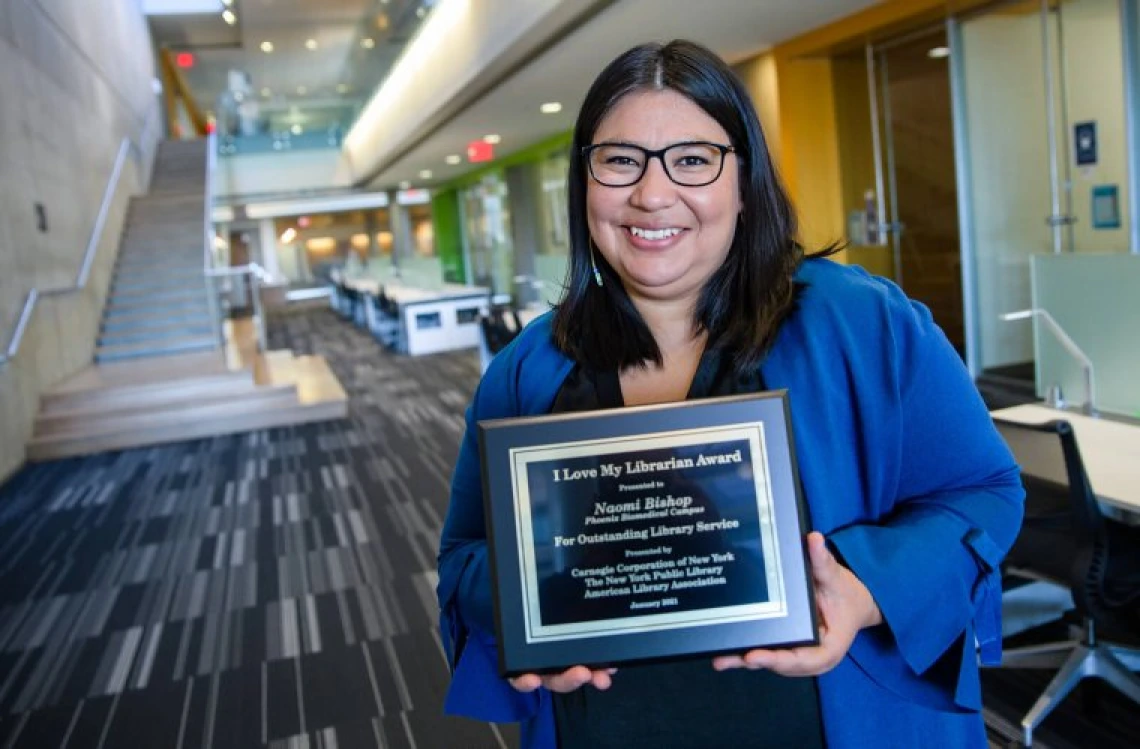 Naomi Bishop holding award