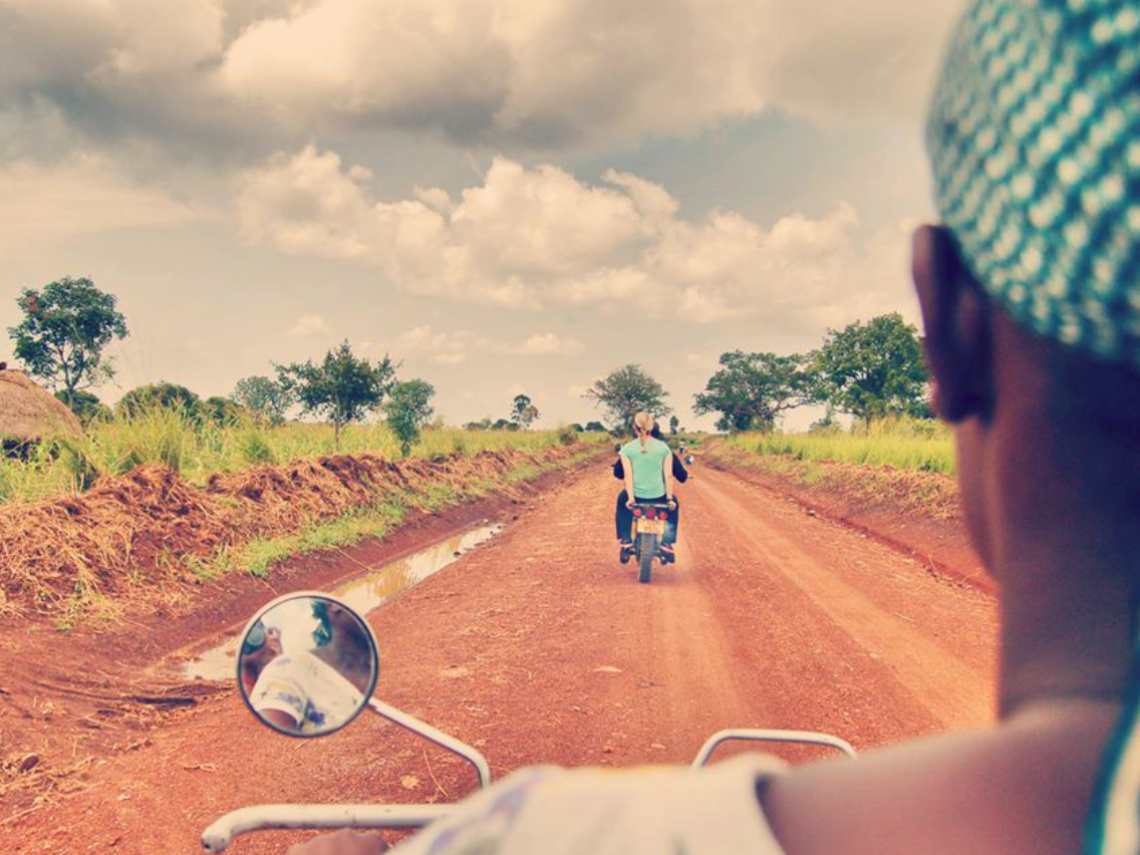 motorcycles traveling on a rural dirt road in Uganda