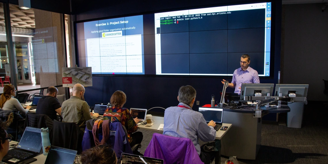 A librarian leading a workshop in a room with a large screen