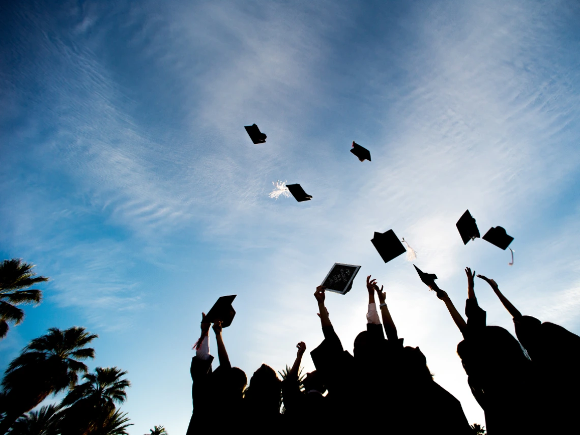 graduating students throwing their caps in the air