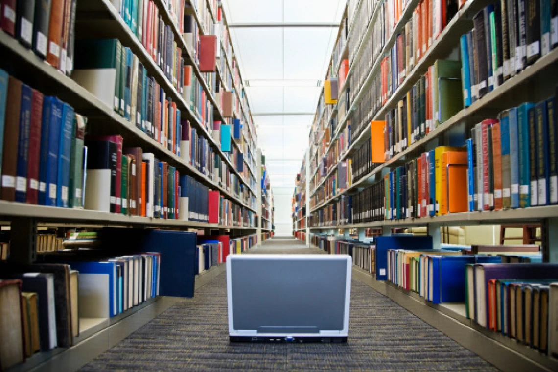 computer screen on the floor in between two bookshelves