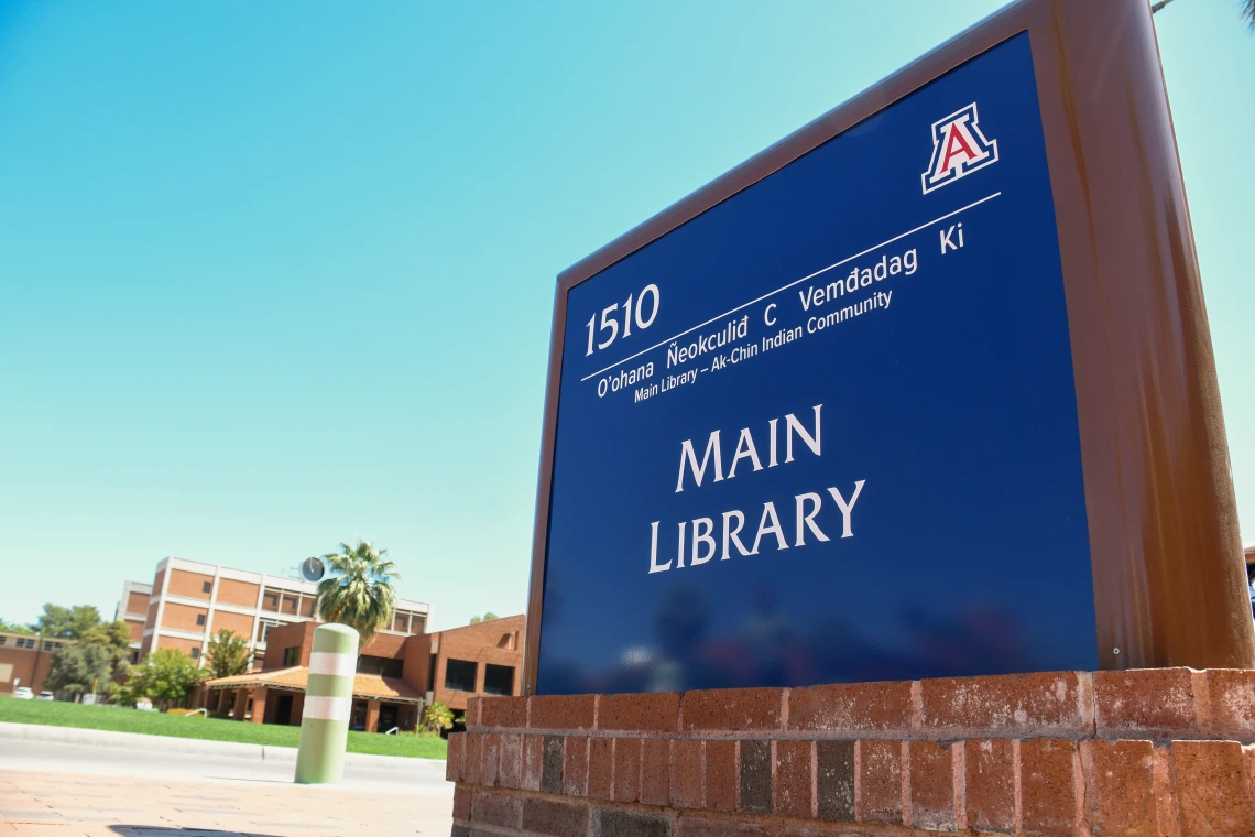 blue main library sign with O'odham translation at the top
