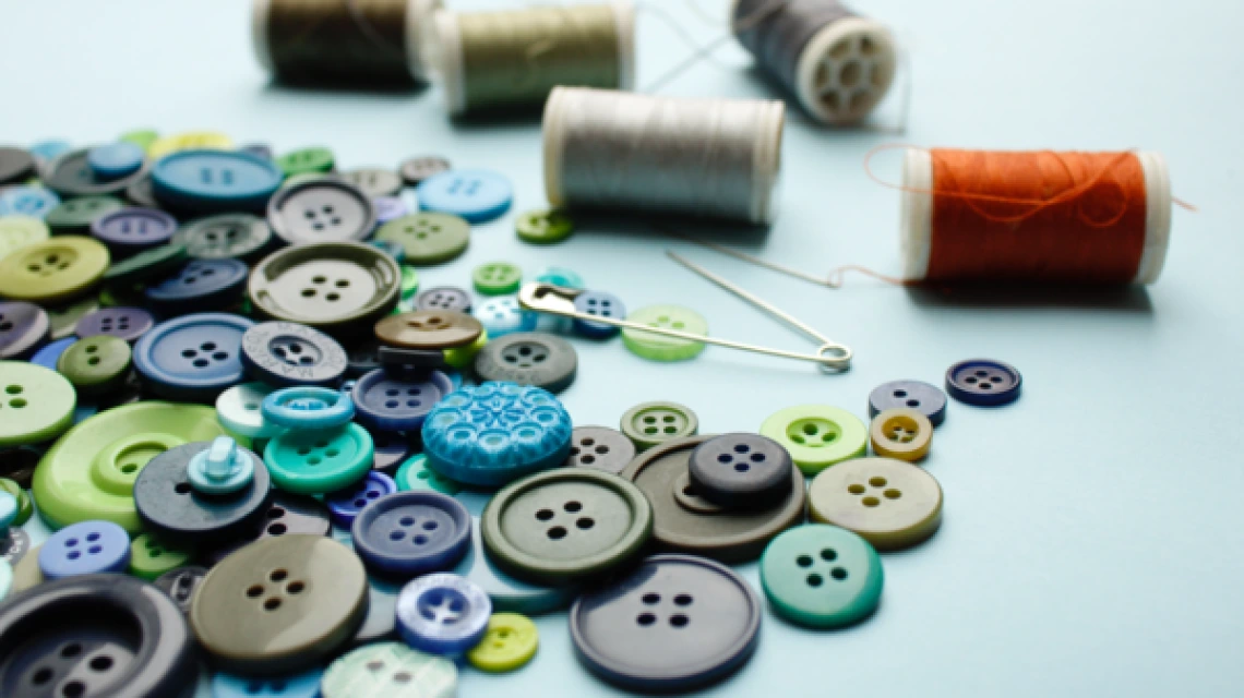 colorful buttons, thread, and sewing needles
