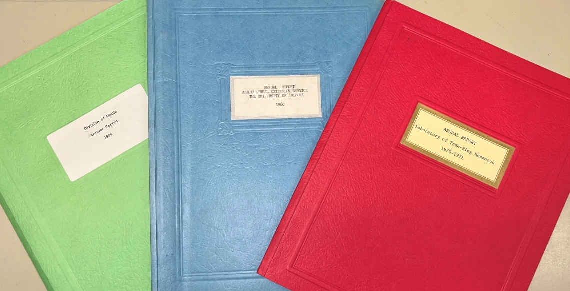 Green, blue, and red folders containing reports to the UA President from 1960, 1970, and 1988.