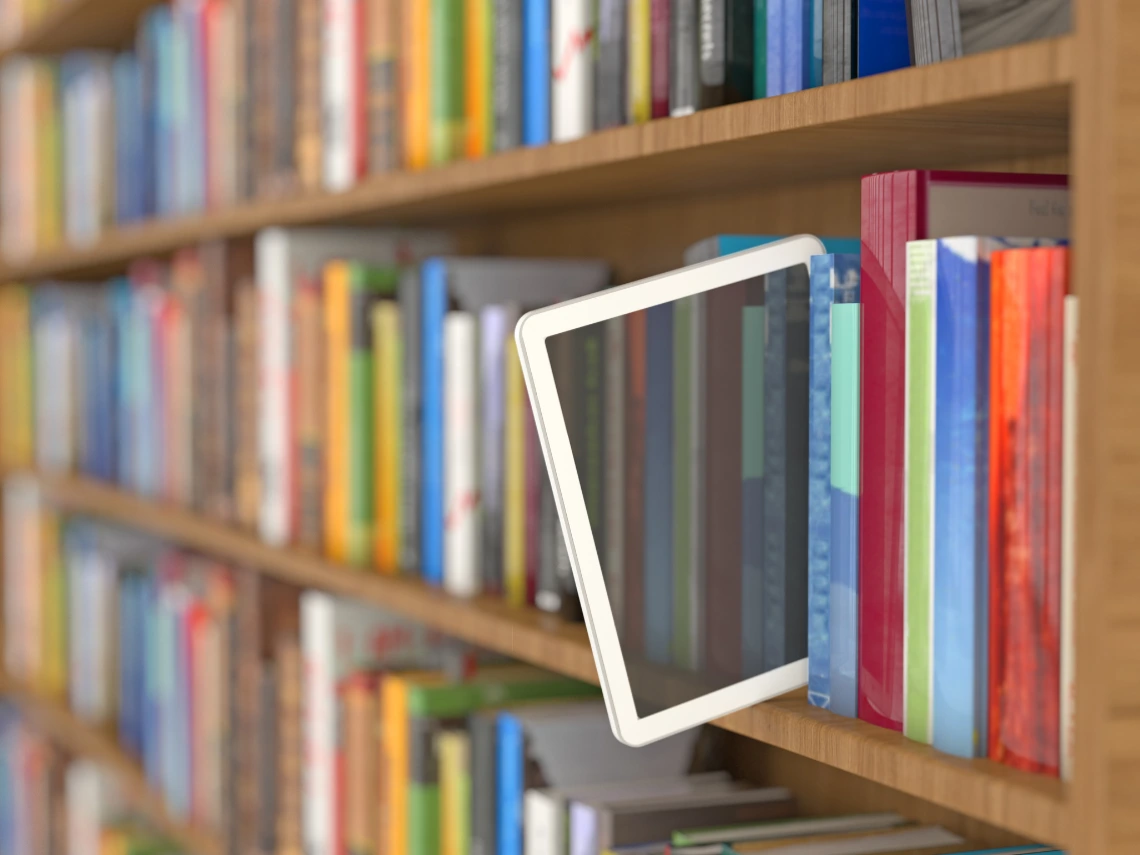 Bookshelf full of books with a screen reader hanging on the edge