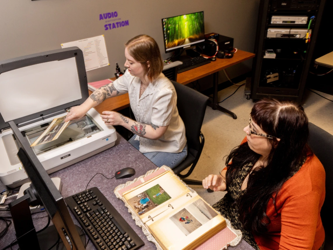Two people using the Memory Lab and scanning photos
