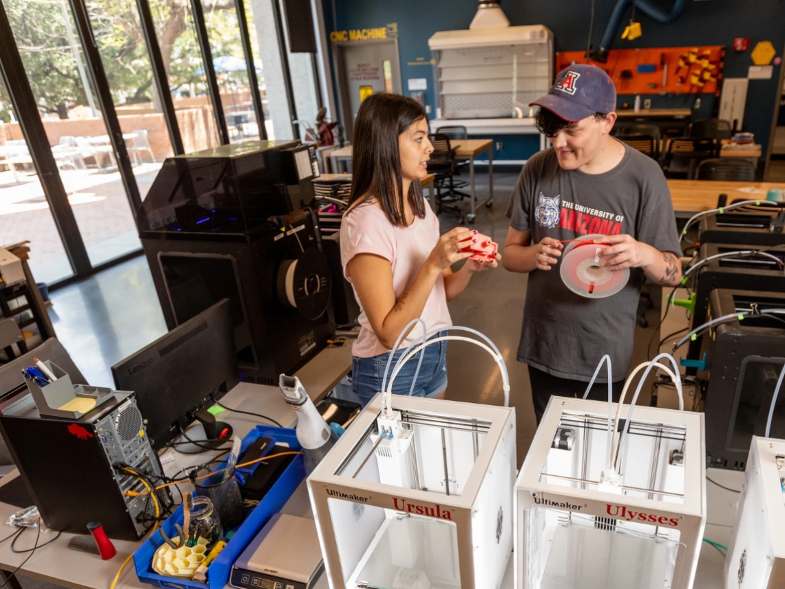 Two people using 3D printers in CATalyst Studios