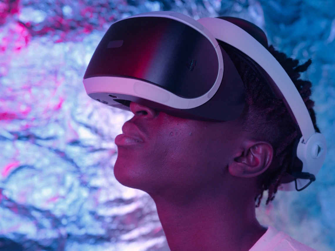 A young person using a VR headset in front of a colorful background