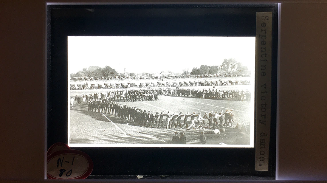 Lantern slide with photograph of parade ground with serpentine victory dance