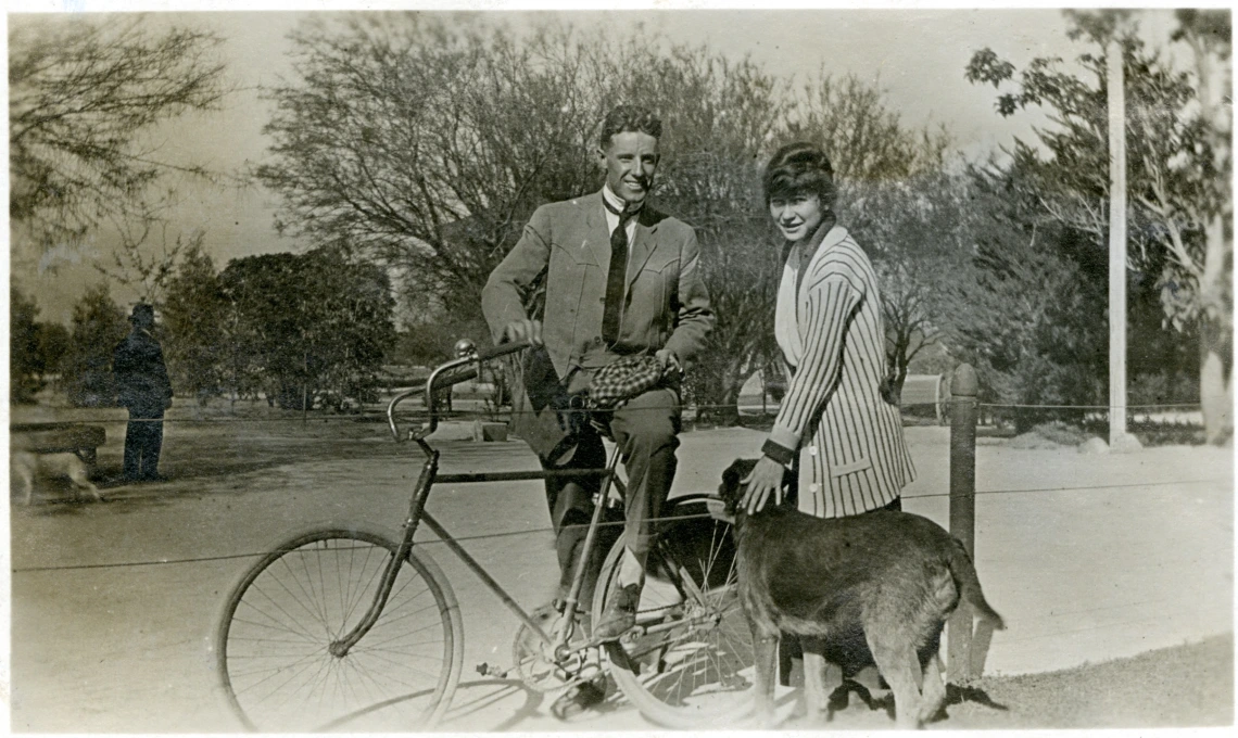 Jessie Esther Rae posing with a bicycle, male companion and large dog