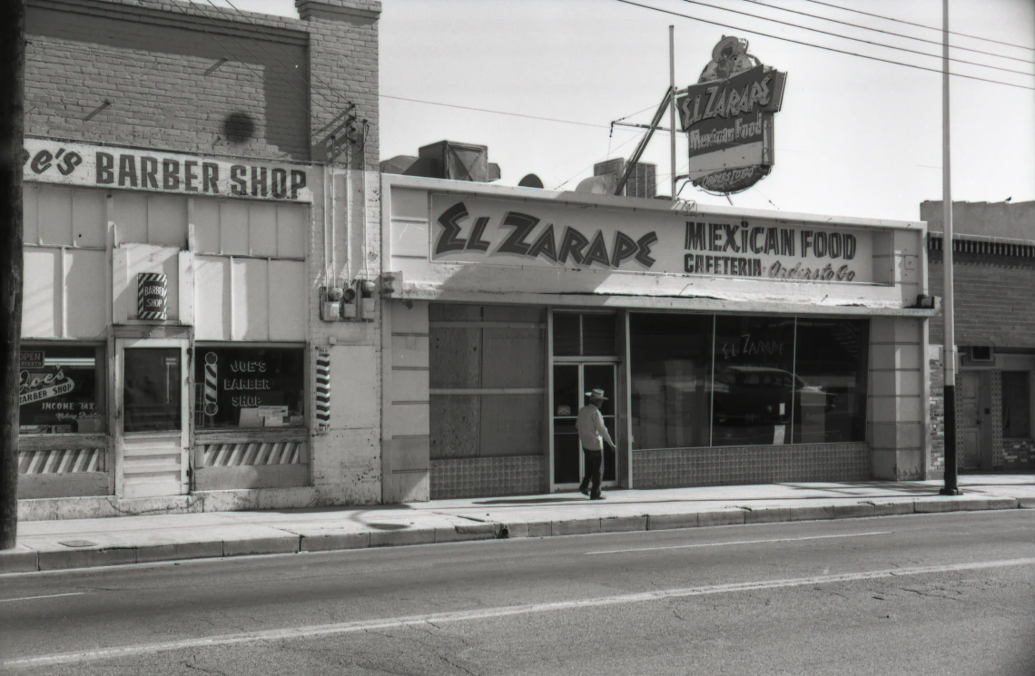 El Zarape restaurant, downtown Tucson, 1968. In this street view, El Zarape, a Mexican food and cafeteria restaurant, is featured. Above the restaurant is a neon sign advertising the establishment.