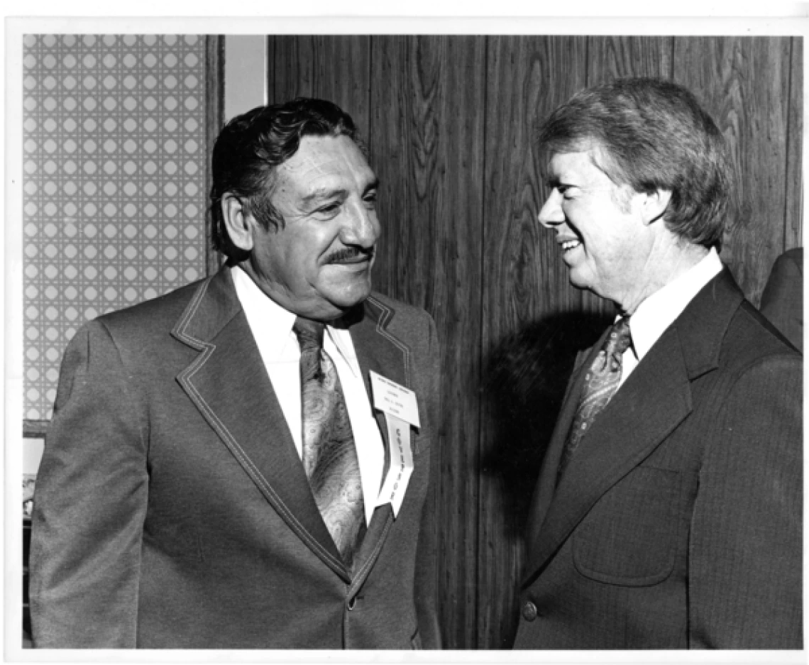 Black & white photo of Governor Castro with President Jimmy Carter, the two men are smiling at one another