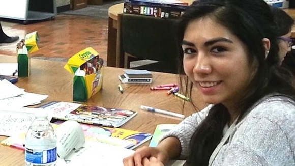 Student sitting with coloring books