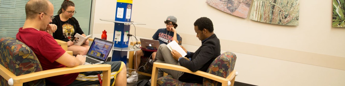 A group of library patrons charge devices at a charging station