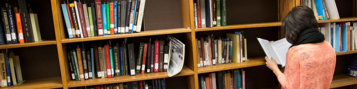 Woman looking at book from the hold shelf