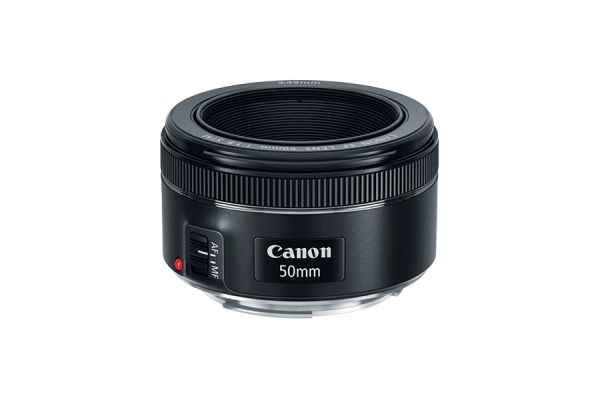 A black, small, cylindrical DSLR camera lens with a focus ring. Its depth and width are more than its height.