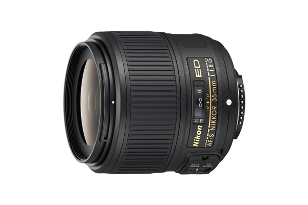 A black, cylindrical DSLR camera lens that has text printed in gold. It has a focus ring. Its height is slightly more than its width and depth.