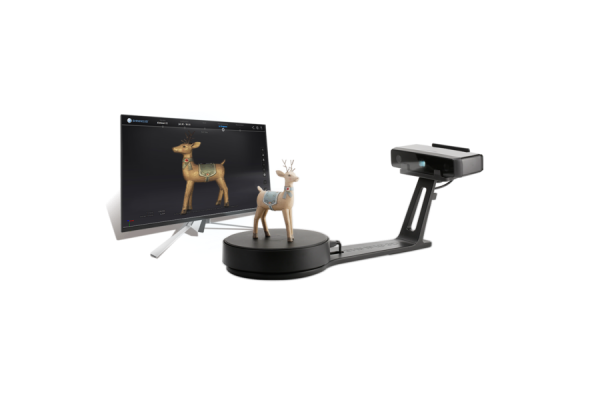 A small, black platform with a small model of a reindeer placed on it. The platform is connected to a small camera that captures the reindeer, and its image shows up on a monitor next to the projector system.